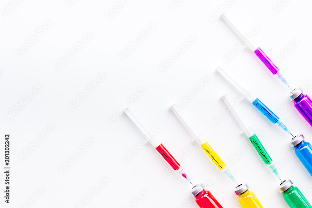 Syringe with colored drug. Injection concept on white background top view copy space pattern Syringe with colored drug. Injection concept on white background top view copy space pattern