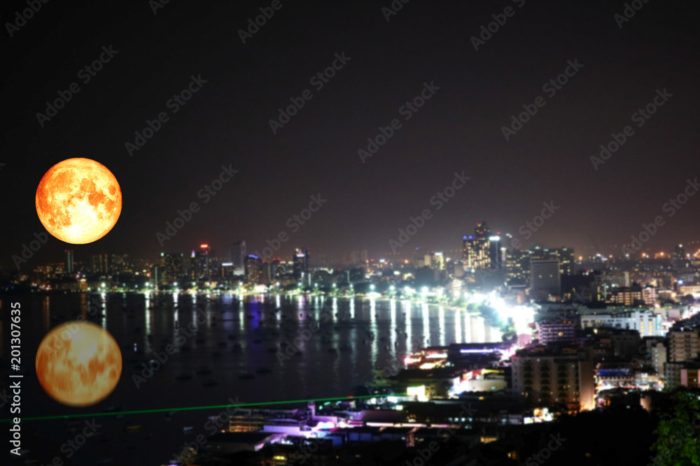 Obraz premium super full blood moon reflection on sea colorful of blur night light over city