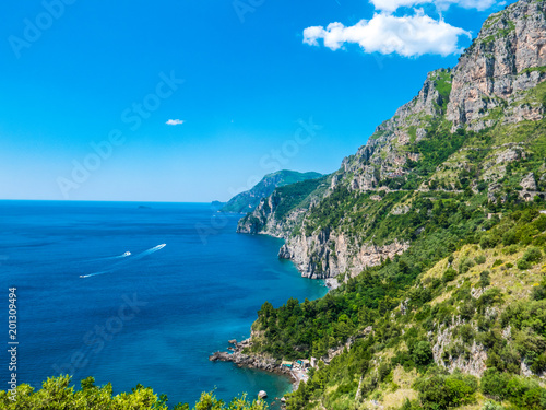 Infinite view of the Amalfi Coast with wild coastline, perfectly preserved environment, vertical rocky cliffs, luxuriant green forest and blue coves of the Mediterranean sea. - Amalfi, Naples, Italy