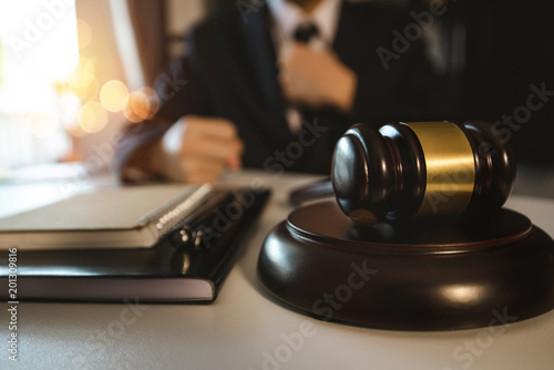 justice and law concept.Male judge in a courtroom the gavel,working with digital tablet computer on white table in morning light 