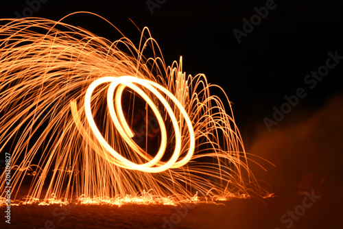 Fire spinning with burning steel wool at night