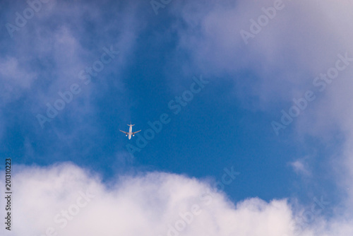 view of plane from ground. travel concept. blue sky with white clouds