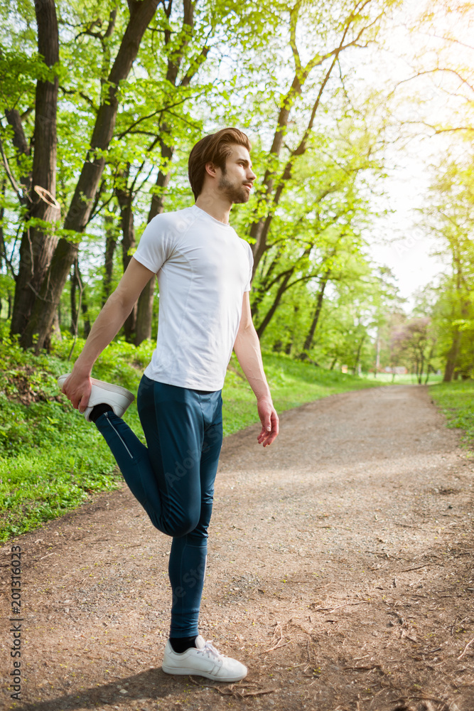 Young man is exercising. He is stretching his body. Young man is exercising. He is stretching his body.