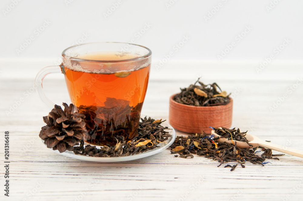Cup of tea with tea leaves scattered.