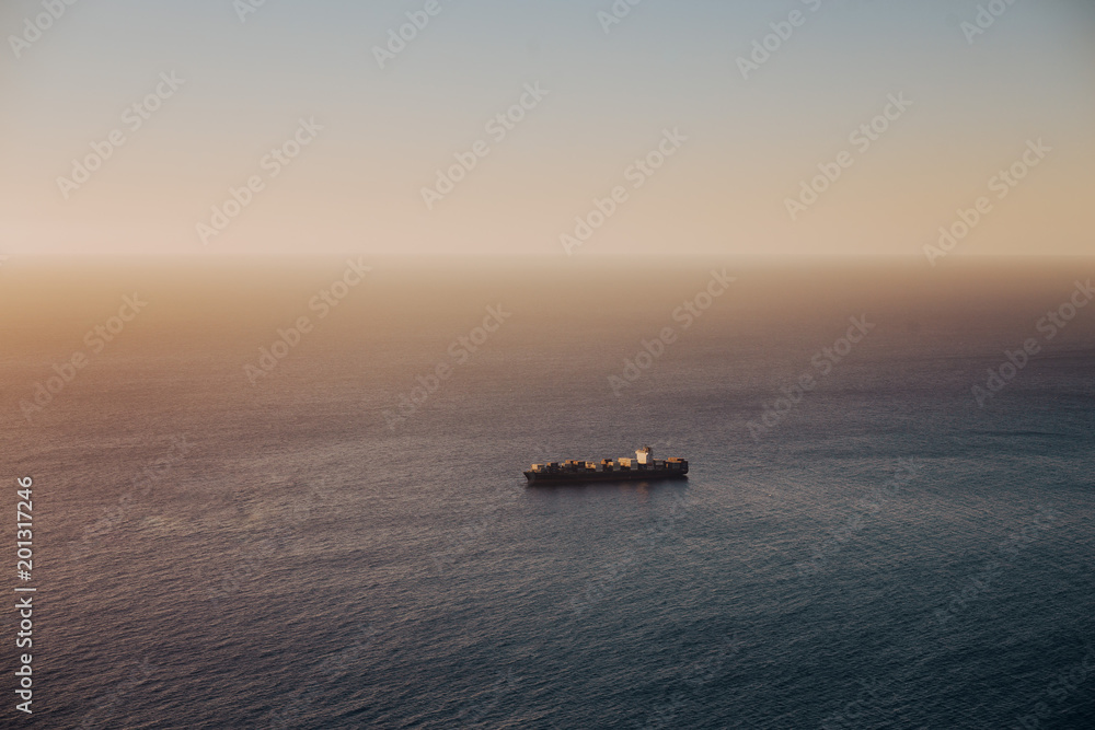 Oil tanker ship on calm ocean at sunset