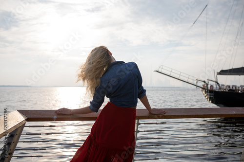 Beautiful woman in red dress on the background of the sea.