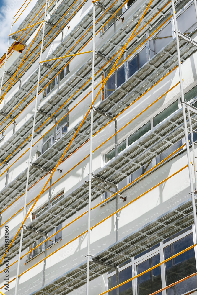 scaffolding near a new house, building exterior, construction and repair industry, white wall and window, yellow pipe scaffolding near a new house, building exterior, construction and repair industry, white wall and window, yellow pipe