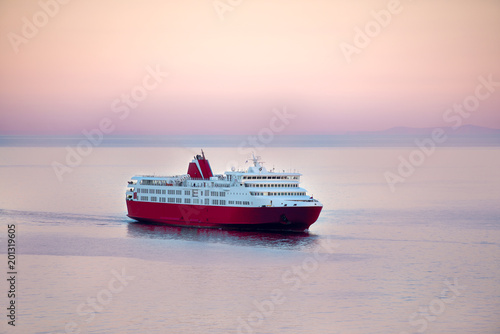 Obraz na plátně Sunset and a blue white ferry boat in greek islands