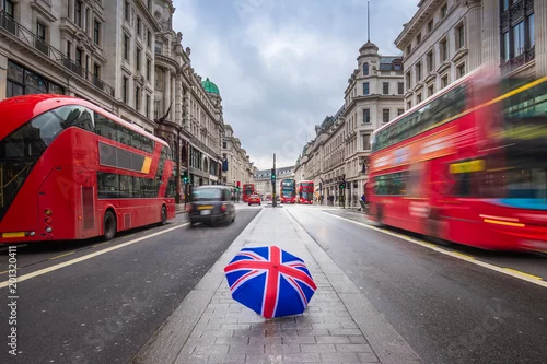 Obraz Londyn, Anglia - brytyjski parasol przy ruchliwej Regent Street z kultowymi czerwonymi piętrowymi autobusami i czarnymi taksówkami w ruchu