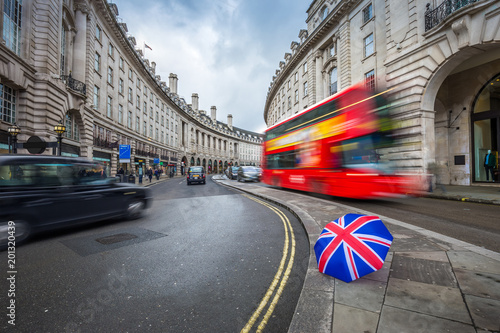 Принти на полотні London, England - Iconic red double-decker bus and black taxies on the move on R