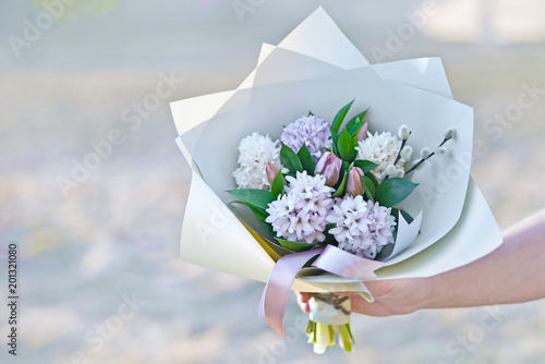 Male hand holdinfg flower bouquet