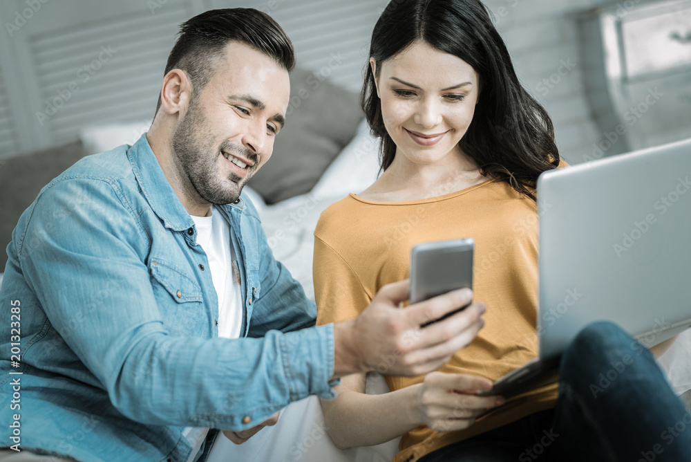 Funny picture. Jovial gay two students staring at phone while smiling and watching video Funny picture. Jovial gay two students staring at phone while smiling and watching video