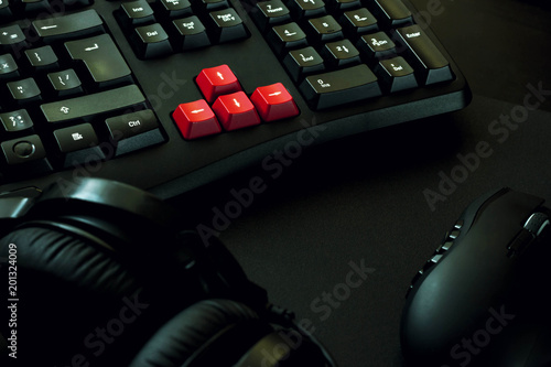 gaming keyboard, headphones and mouse on black table