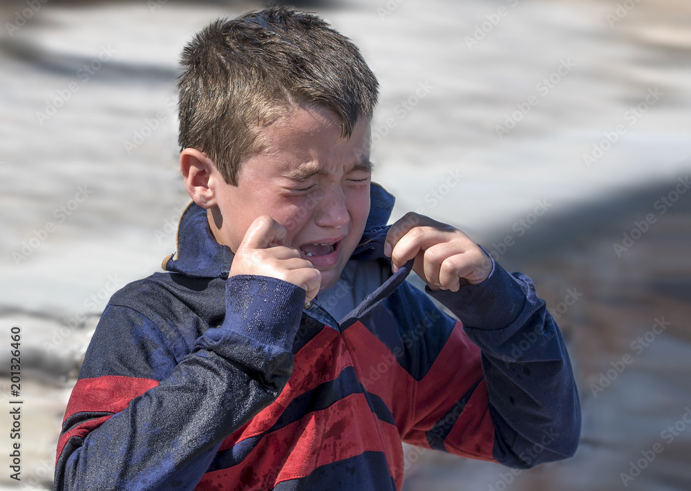 When a big wave splashed all over a 6 year old boy , he started crying as he was frightened and wet. When a big wave splashed all over a 6 year old boy , he started crying as he was frightened and wet.
