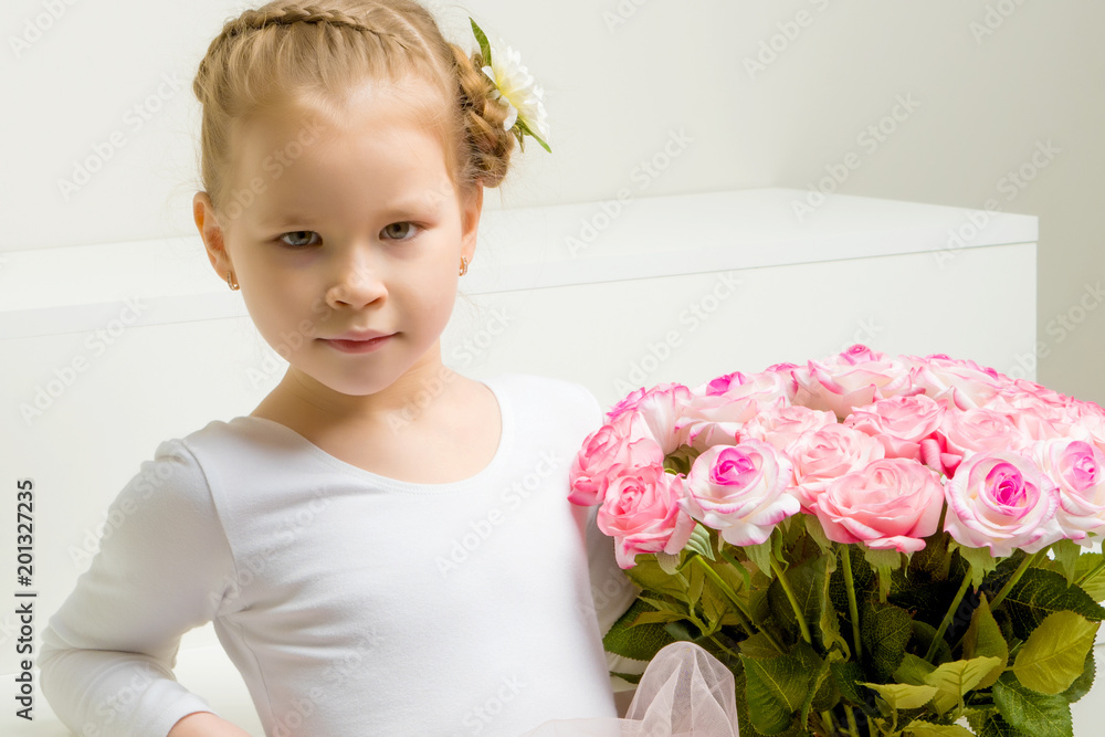 Little girl with a bouquet of flowers sits on a white staircase. Little girl with a bouquet of flowers sits on a white staircase.