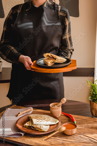 Mexican burrito with chicken, vegetables, pepper and beans. Burrithos quesadilla food in hand. photo