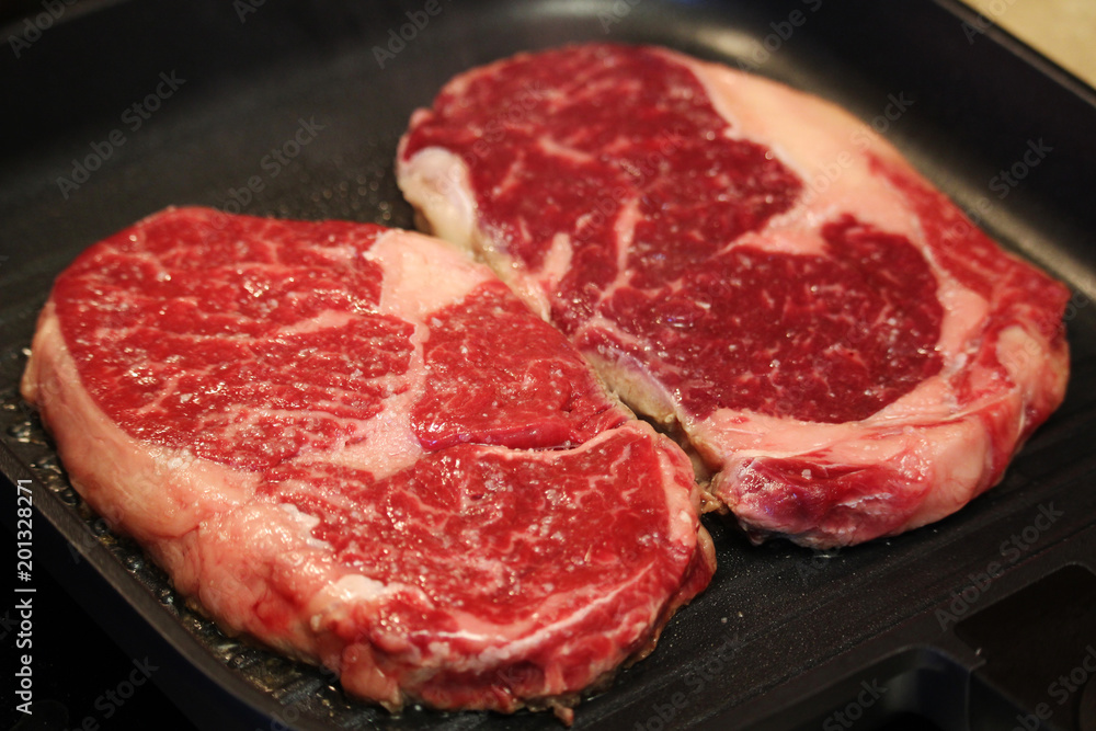 Raw steaks cooked on the pan Raw steaks cooked on the pan