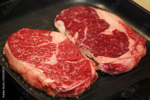 Raw steaks cooked on the pan