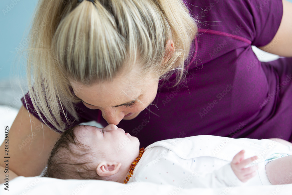 beautiful blond mother with her 3 month old baby wearing a amber necklace beautiful blond mother with her 3 month old baby wearing a amber necklace