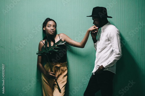 Cheerful beautiful african american couple looking at each other over green background