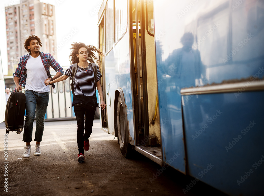© Dusan Petkovic - Young couple is rushing to catch a blue bus while holding each others hands. © Dusan Petkovic - Young couple is rushing to catch a blue bus while holding each others hands.