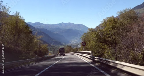 Highway in the mountains, Cinema 4k pov view driving on a road in the swiss alps, towards Brig city, on route e62, on a sunny autumn day, down from the Simplon pass, in Valais, Switzerland photo