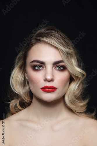 Young beautiful woman with blonde curly hair and red lipstick