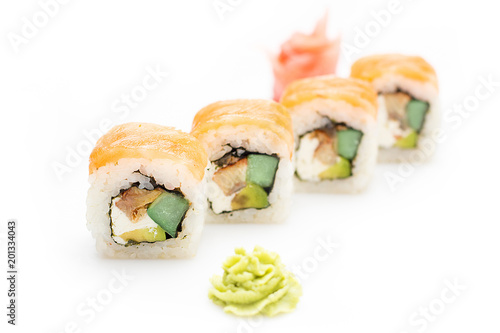 Appetizing sushi rolls with avocado, cucumber, eel and Philadelphia cheese wrapped in salmon. Isolated. Sushi roll on a white background.