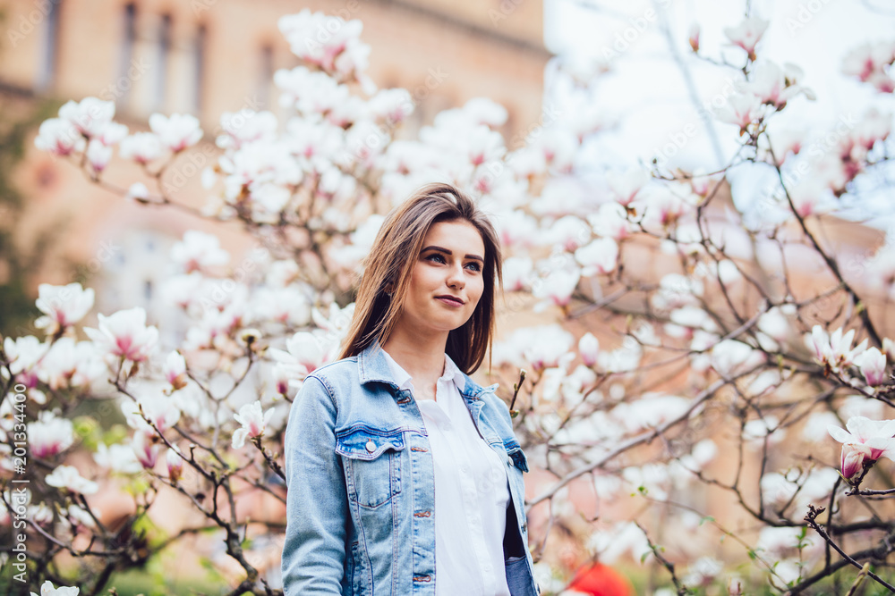 Young beauty girl in spring blooming flower of magnolia tree Young beauty girl in spring blooming flower of magnolia tree