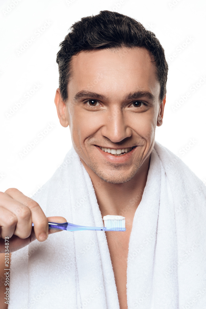 Portrait of handsome man with towel brushing his teeth in morning isolated. Portrait of handsome man with towel brushing his teeth in morning isolated.