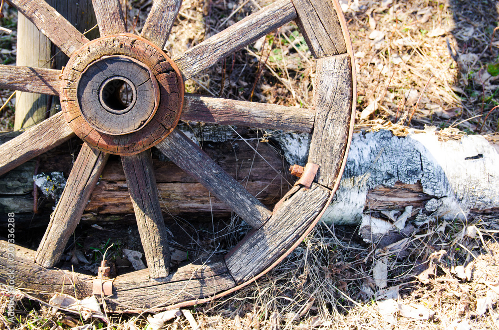 Old wooden cart wheel. The concept of outdated technologies, ecotourism Old wooden cart wheel. The concept of outdated technologies, ecotourism