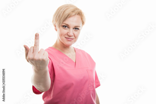Attractive female nurse wearing pink scrubs showing obscene gesture