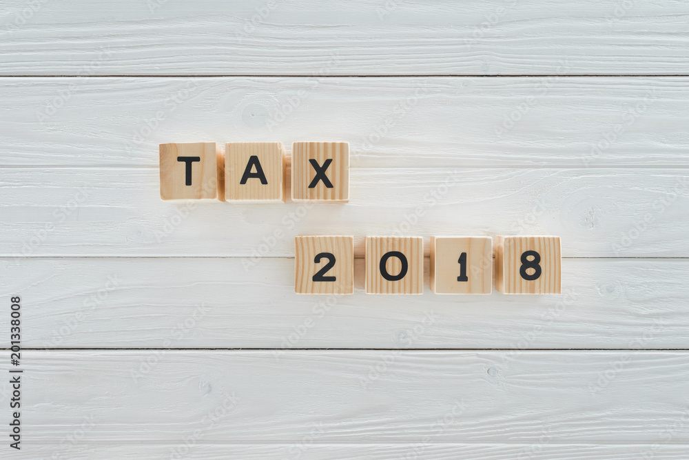 top view of wooden blocks arranged in tax 2018 inscription on white wooden tabletop top view of wooden blocks arranged in tax 2018 inscription on white wooden tabletop
