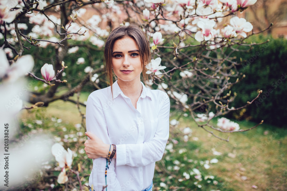 beautiful young woman near the blossoming spring tree. Magnolia blossom. beautiful young woman near the blossoming spring tree. Magnolia blossom.