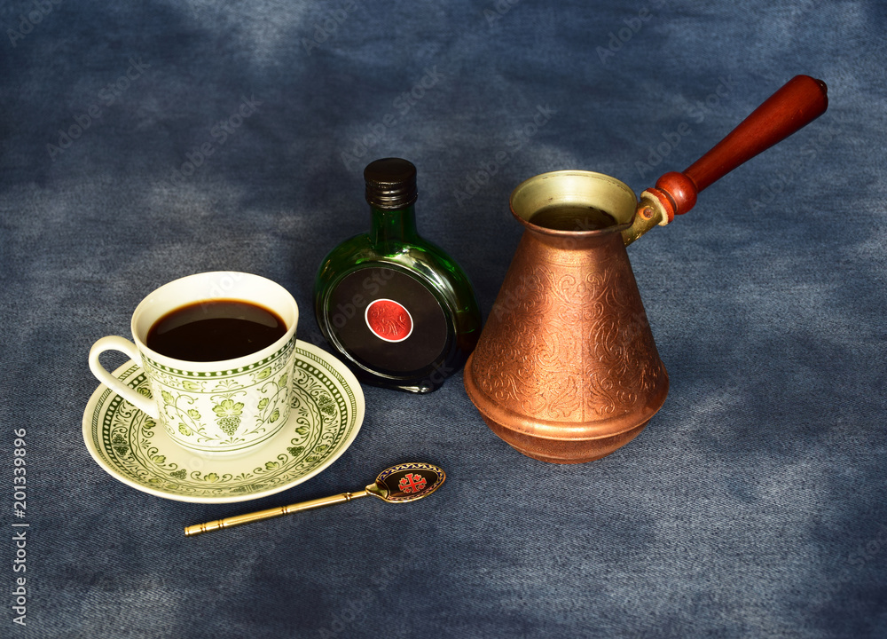 The still life consists of a cup of coffee, a bottle of balsam and a coffee maker. Russia, March, 2018. The still life consists of a cup of coffee, a bottle of balsam and a coffee maker. Russia, March, 2018.