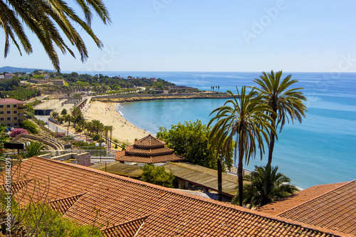 View of coastline of Costa Dorada in Miami Platja, sea, beach, palms and tiled roofs of houses with Mediterranean Balcony, Tarragona, Catalunya, Spain photo