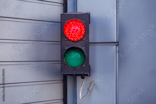 Two-color small traffic light. Red and green colors. Red light is on it