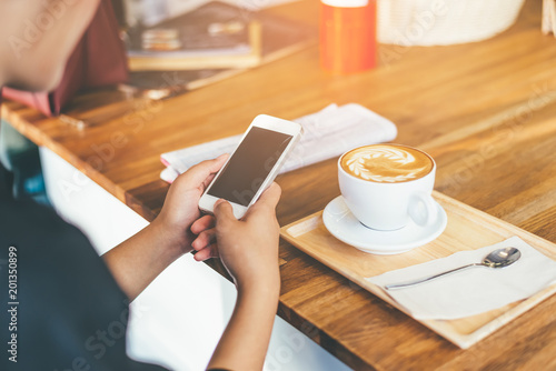 hand using smartphone in coffee shop