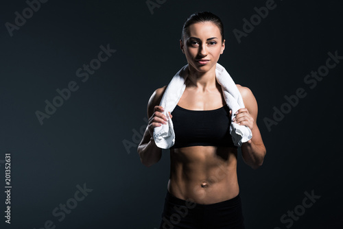 attractive bodybuilder posing with towel after training, isolated on grey