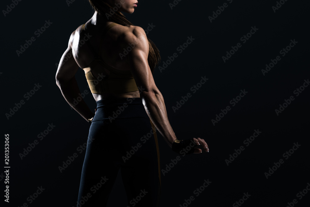 female bodybuilder posing and showing muscles, isolated on black