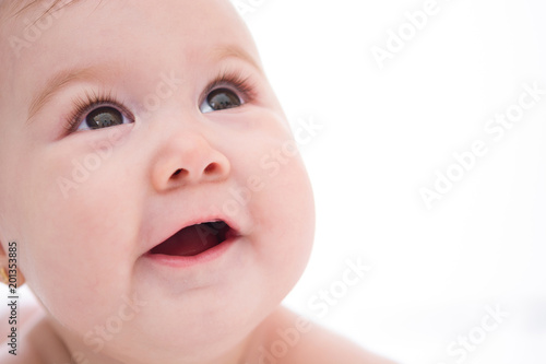 Adorable little baby girl smiling on white background. Close up  
