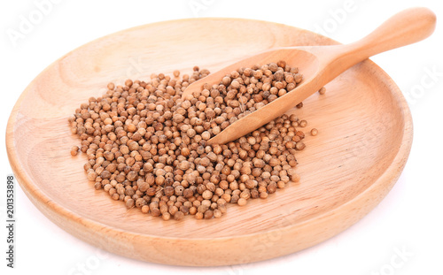 Coriander seeds in wood spoon on white background