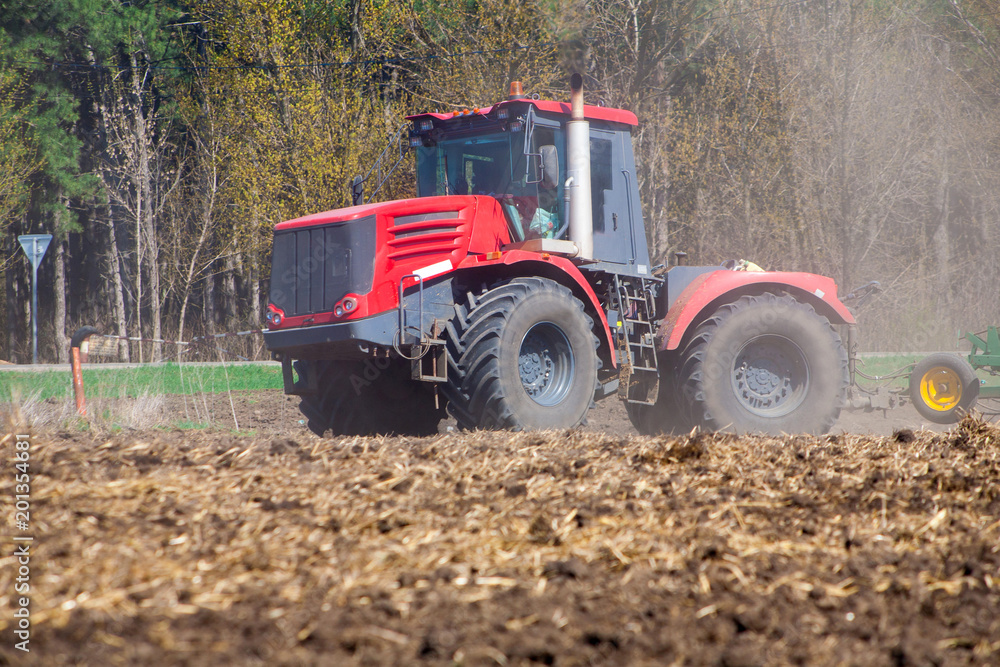 Farmer in tractor preparing land with seedbed cultivator Farmer in tractor preparing land with seedbed cultivator