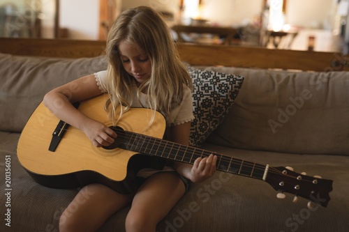 Girl playing guitar at home