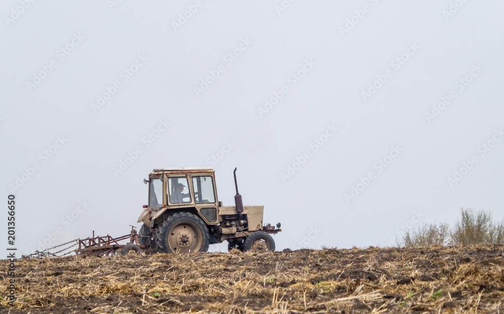 Tractor prepares a field for sowing