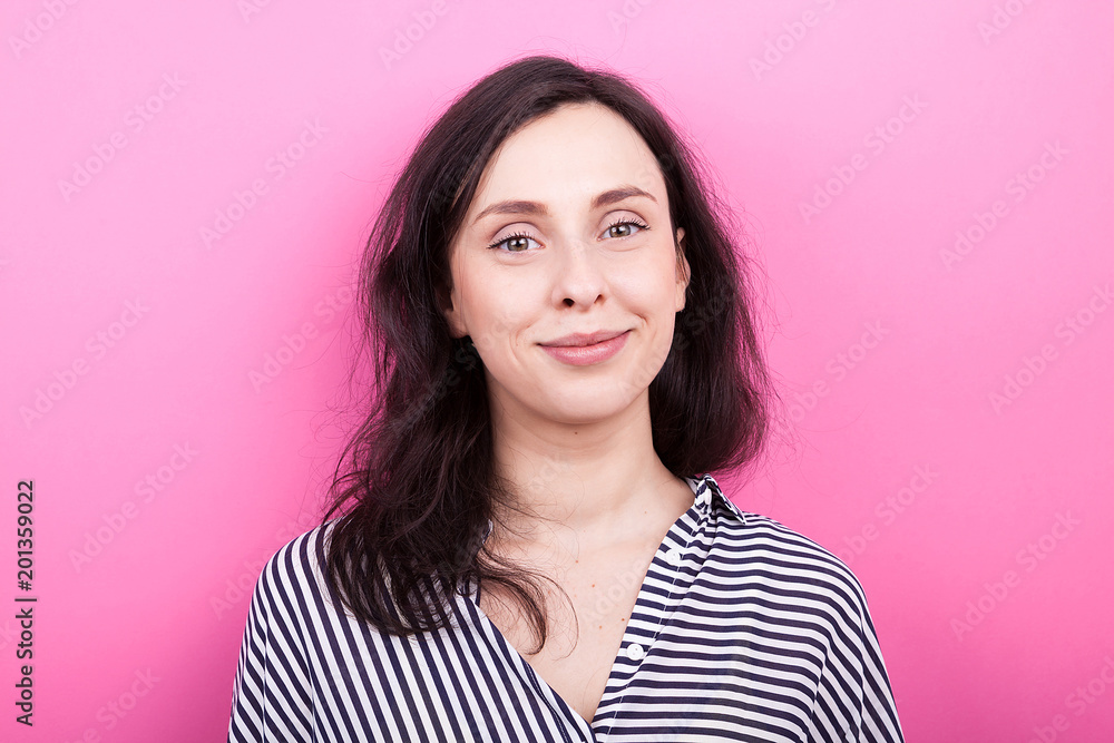 Portrait of smiling young woman on pink background in studio Portrait of smiling young woman on pink background in studio