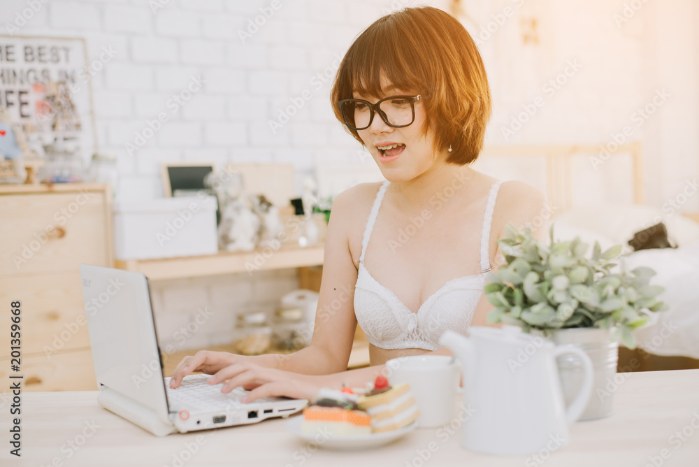 portrait of a young sexy beautiful and happy woman in bikini using laptop and lying portrait of a young sexy beautiful and happy woman in bikini using laptop and lying
