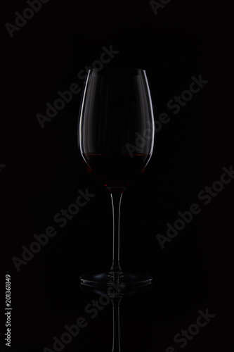 closeup shot of glass with red wine isolated on black background