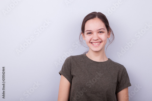 Portrait of smiling happy girl on gray background in studio photo