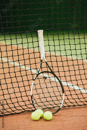 Tennis racket and 3 balls on the tennis court grid close-up. Sports Equipment